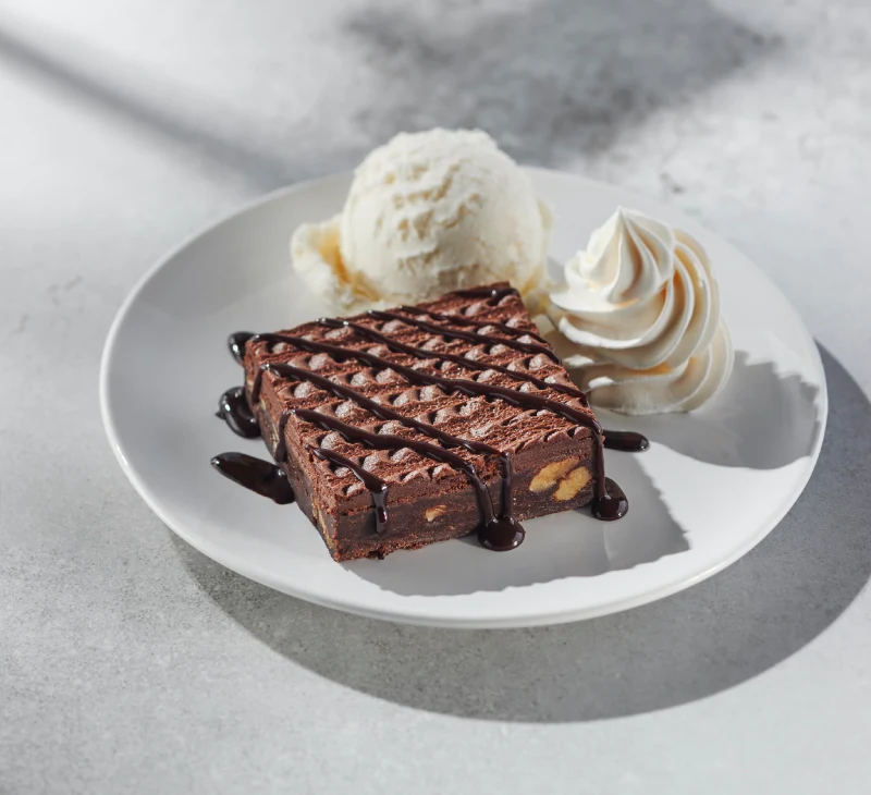 Brownie classique avec un délicieux brownie servi avec une boule de crème glacée à la vanille (en salle à manger seulement), de la crème