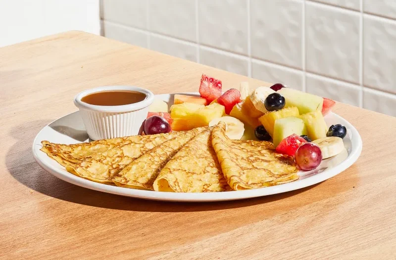 Thin Crepes with five thin crepes topped with whipped cream and powdered sugar