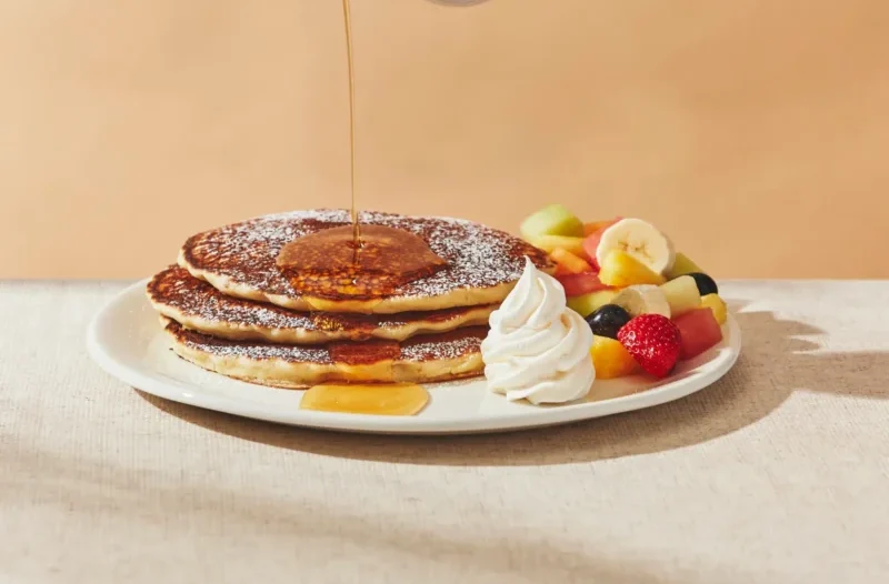Traditional Crepes with three fluffy crepes topped with whipped cream and powdered sugar