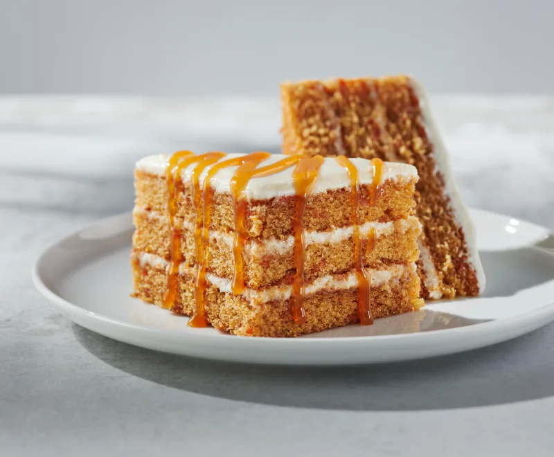 Gâteau aux carottes velouté avec un gâteau onctueux fait avec un glaçage au fromage à la crème vanillée, le tout accompagné d’un coulis au choix