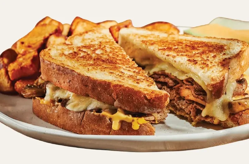 Grilled cheese philly avec sandwich au fromage mozzarella fondu, garni de steak Philly savoureux, d’oignons, de champignons sautés et de sauce
