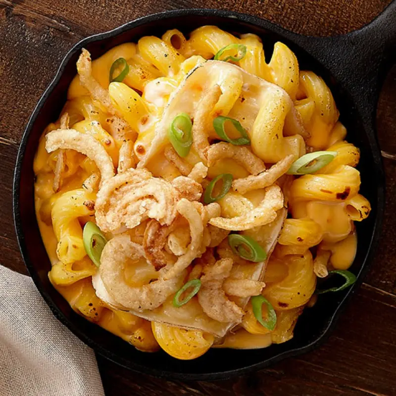 Mac & Cheese with cavatappi pasta in creamy three-cheese sauce and Cantonnier cheese, topped with green onions and crispy onions