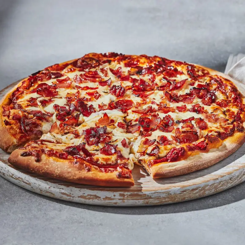Canadian pizza with signature pizza sauce, pepperoni, bacon, onions, and mozzarella pizza cheese