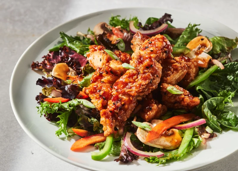 Thaï-llement fraîche, Filets de poulet croustillants enrobés d’une sauce général Tao et servis sur un mélange de laitue mesclun, poivrons rouges