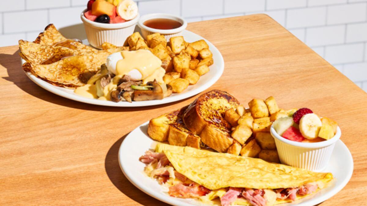 deux assiettes déjeuners : omelettes jambon et oeuf benedictine steak philly avec patates et fruits