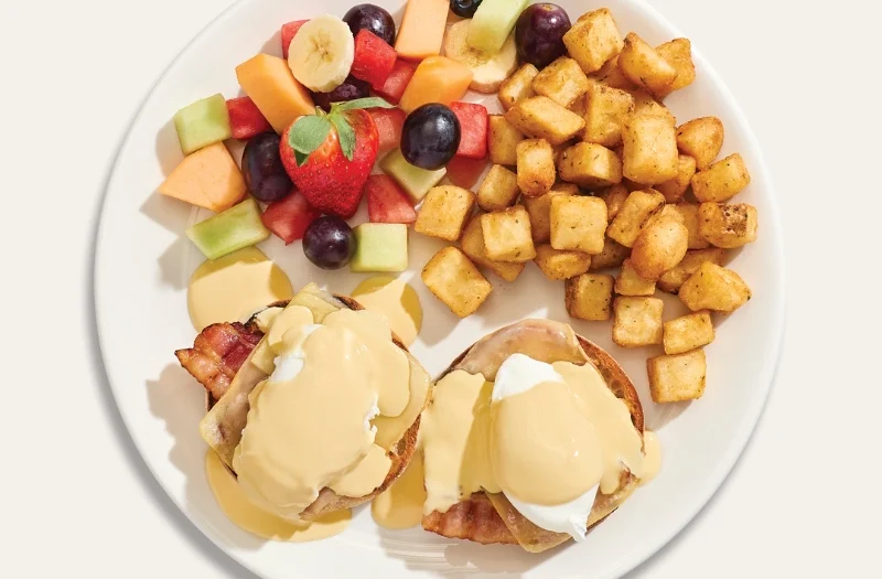 Cantonnier with poached egg(s) served on an English muffin with bacon and Cantonnier cheese, topped with hollandaise sauce