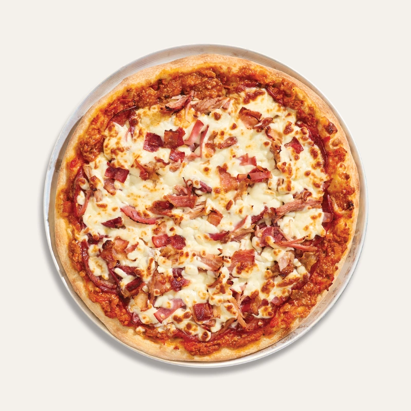 Carnivore pizza with bolognese sauce, pepperoni, capicollo, bacon, ham, and mozzarella pizza cheese