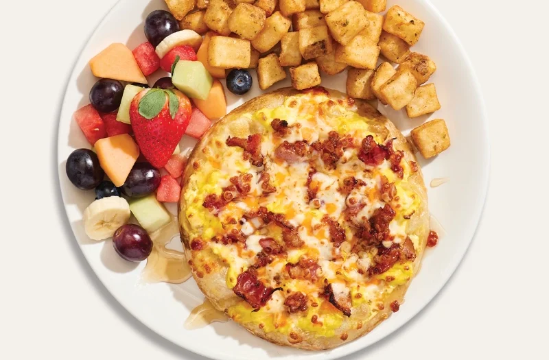 Sucrée-salée avec oeufs brouillés, bacon, sauce hollandaise, sirop d’érable et mélange de trois fromages